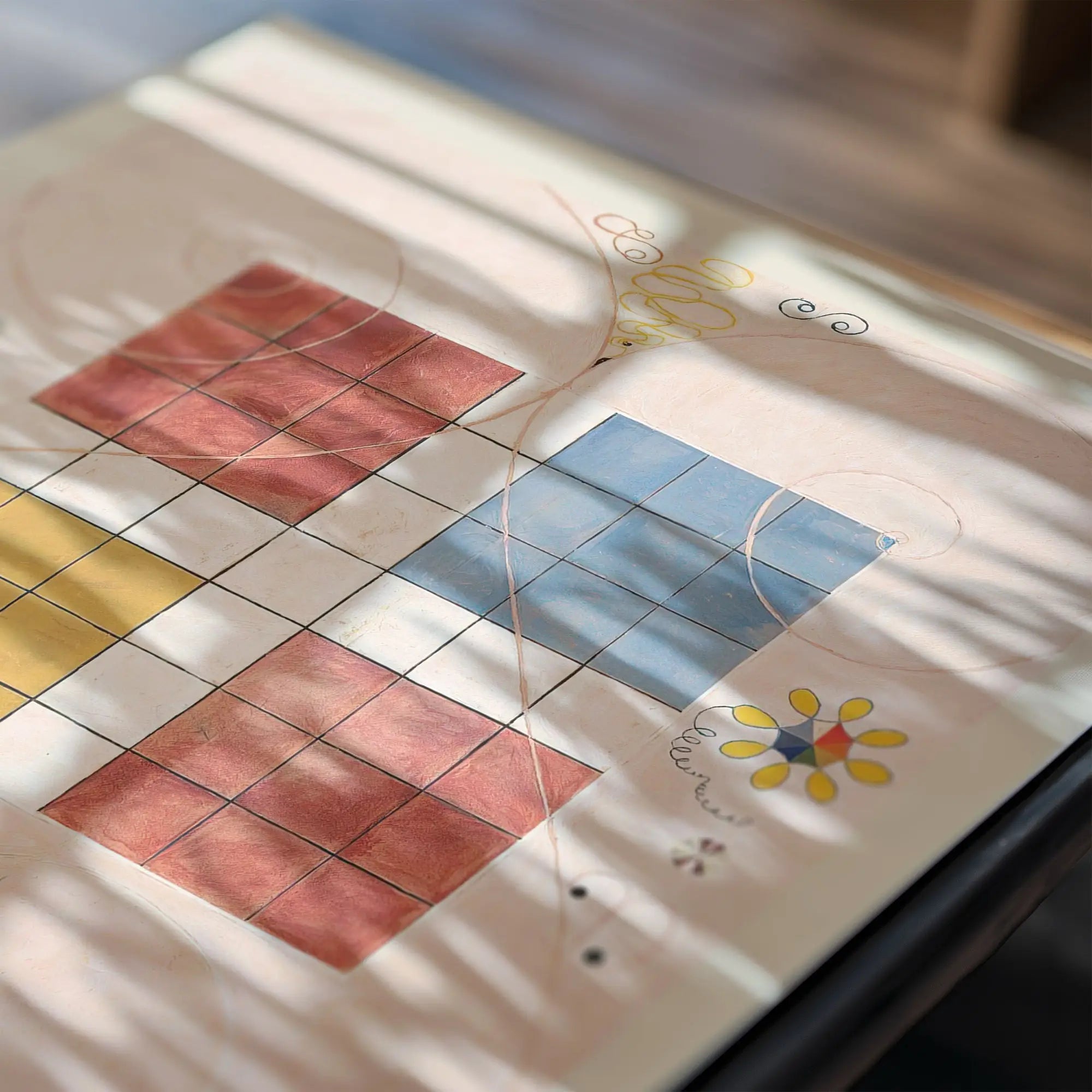 Kleurrijk diamantpatroon op tafel met poster Hilma af Klint De Tien Grootste No 10