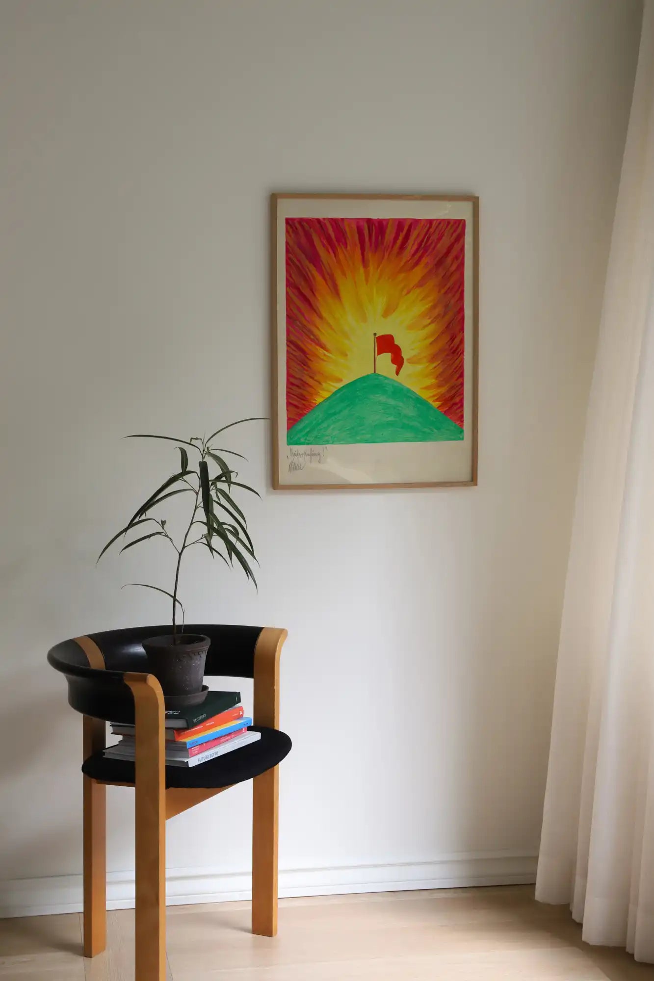 Houten stoel met zwarte zitting en plant.