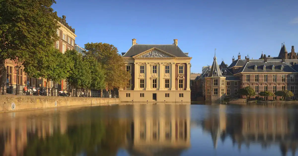 Versierde gebouwen weerspiegeld in water.